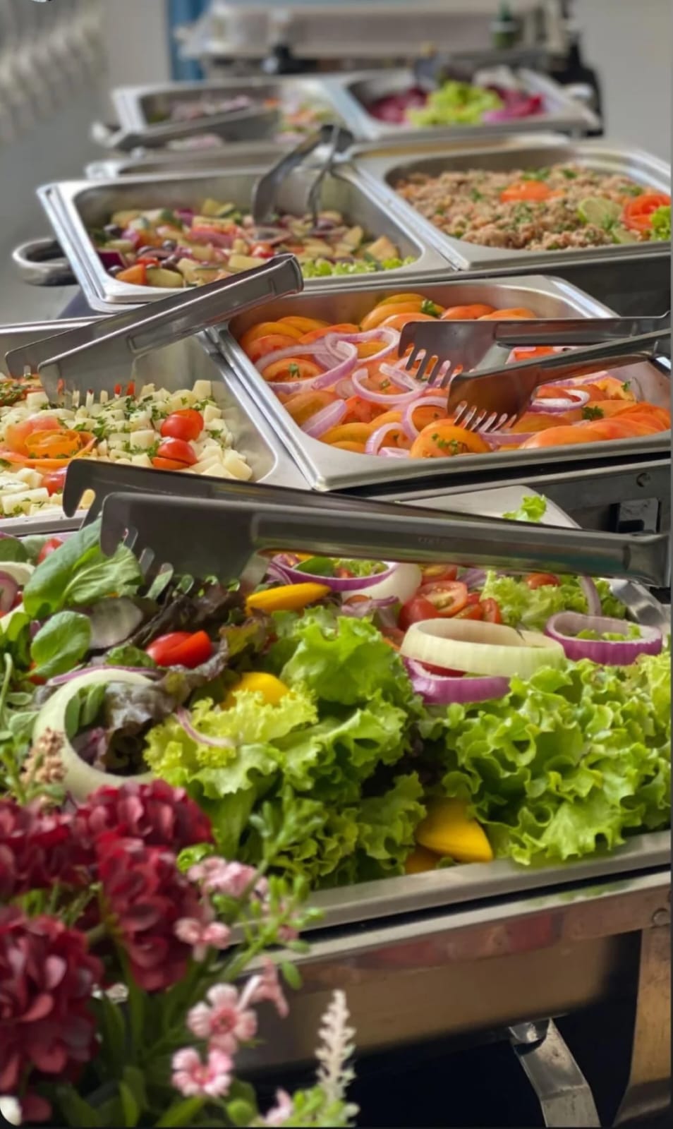 Mesa de saladas montada em cubas térmicas no catering de um set de filmagem