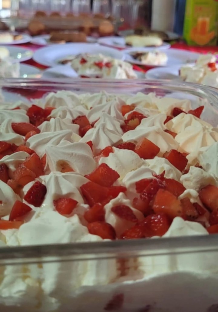 Sobremesa de morango com chantilly servida em travessa durante diária de produção